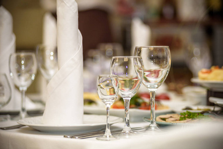 在舒适的餐厅吃晚饭送达的眼镜 叉 刀 餐巾和桌上的装饰花