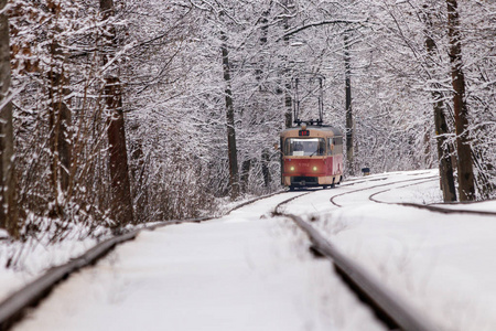 一辆旧电车在冬季森林中穿行