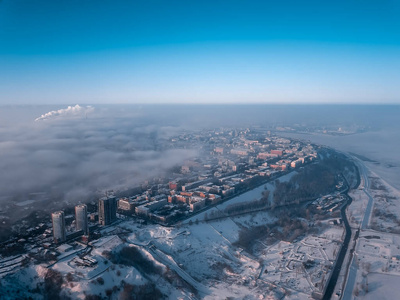 s eye view to a winter city at dawn in the fog