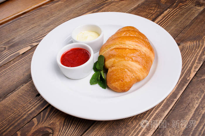 木制桌子上的甜牛角面包