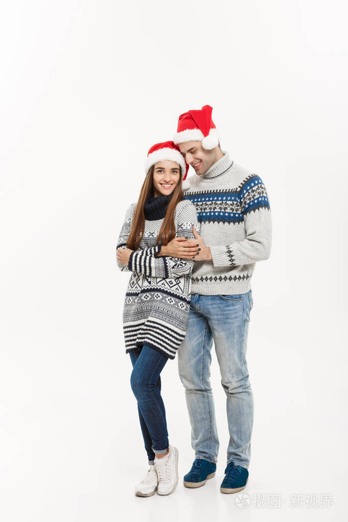 圣诞概念全长年轻迷人的白种情侣给一个拥抱庆祝圣诞日