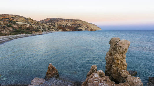 夕阳的最后一线染红了塞浦路斯海岸阿芙罗狄蒂湾周围的群山。