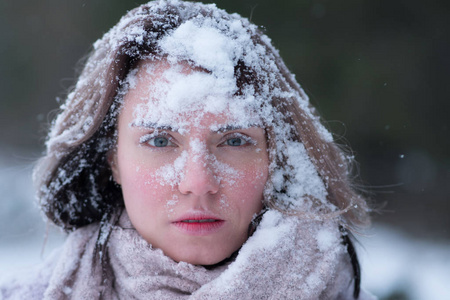 一个年轻美丽的女孩在冬天的户外公园和雪的肖像。