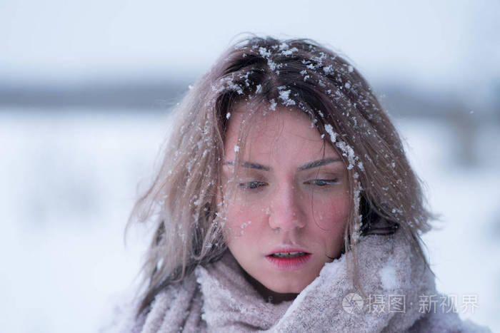 一个年轻美丽的女孩在户外的肖像，冬天的脸在雪地里