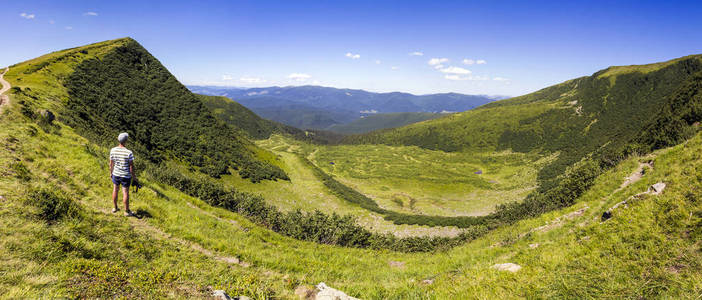 孤独的人徒步旅行站在宽阔的山坡上 enjyoing 山景