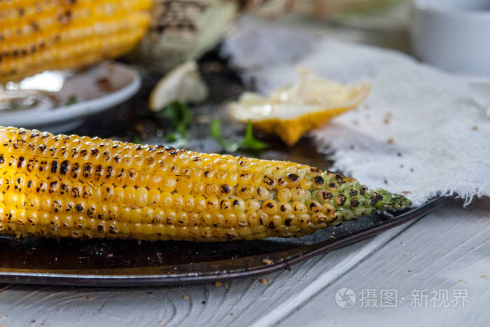 用柠檬香草和香料在木盘上烤玉米