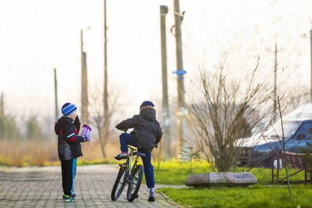 男孩朋友在自行车外面.户外玩耍的孩子照片
