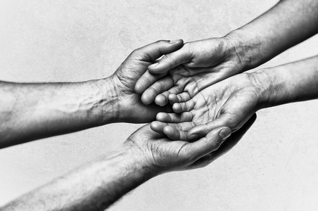 s hands holding female palms on scratched background. Black and 