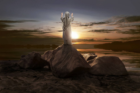 亚洲穆斯林小女孩在夕阳下祈祷的背影照片