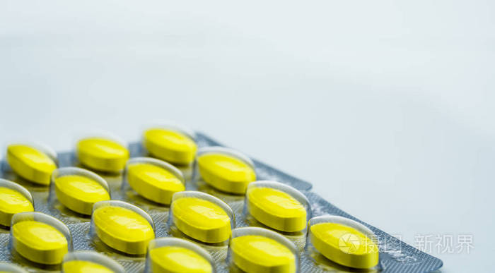 白色背景的黄色椭圆形片剂丸的宏观镜头细节与复制空间 止痛药缓解妇女月经痉挛的药物照片 正版商用图片11e1g6 摄图新视界