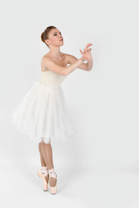 指出的芭蕾舞演员和白色的礼服跳舞