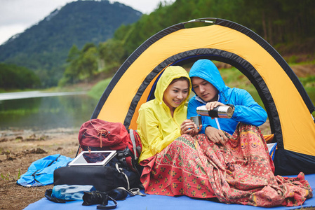 希克给女朋友倒茶，在帐篷里休息