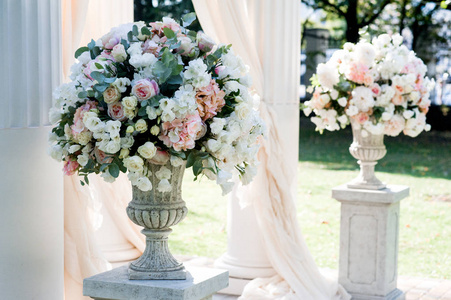 白色婚礼拱门与大桃花束在白色立场
