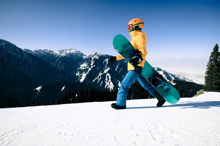 一个滑雪板和一个滑雪板在冬天的山顶上行走