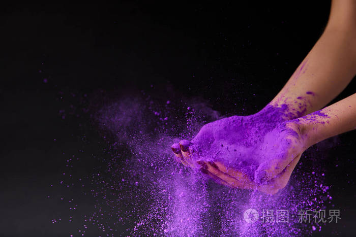 女性双手用黑色分离的紫色全息粉末裁剪
