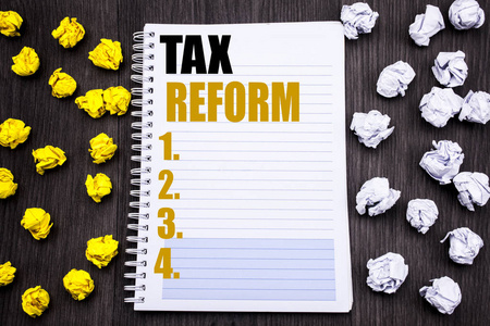 概念性手写文字标题显示税制改革。政府改变税收的商业概念记事本笔记笔记本电脑书木背景粘稠折叠黄色和白色