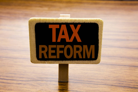 概念性手写文字标题启示显示税制改革。政府在木制木材背景公告板上的税收变动的商业概念