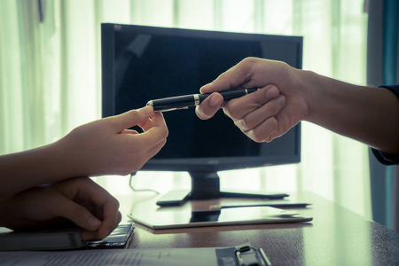 商人把笔递给女人签合同照片