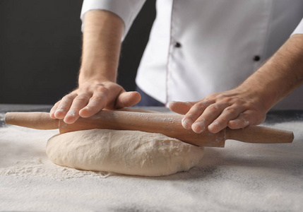 擀面团的人在桌子上撒上面粉照片