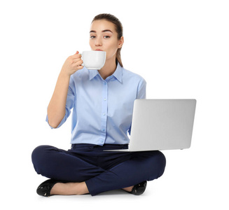 年轻的女商人与笔记本电脑和杯咖啡坐在莲花位置白色背景