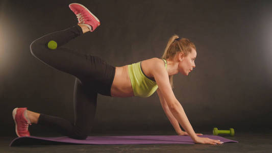 健身妇女在运动服装训练中腹部抬起腿