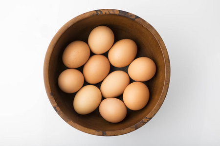 食物木碗中棕色鸡蛋的顶部视图，在工作室的白色背景拍摄中分离出来