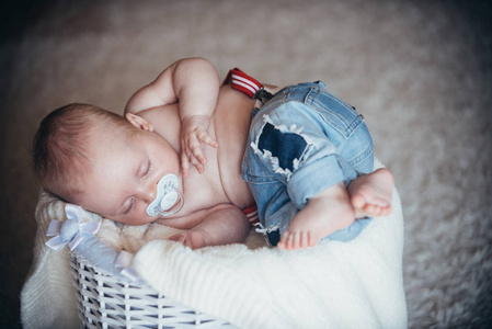 婴儿牛仔裤睡在篮子在地板上