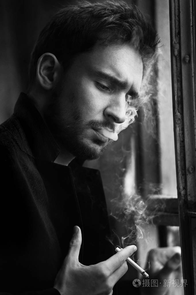 有胡子的人笑了. 穿着深色夹克的性感男人,有自信的脸.