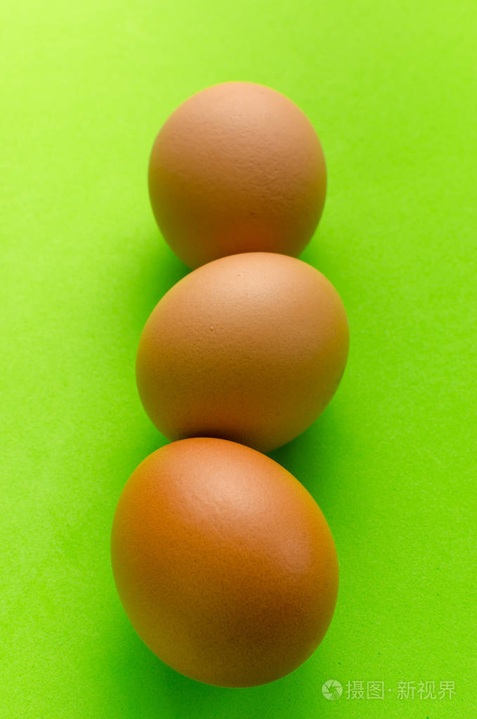 三鸡蛋在一个明亮的绿色背景
