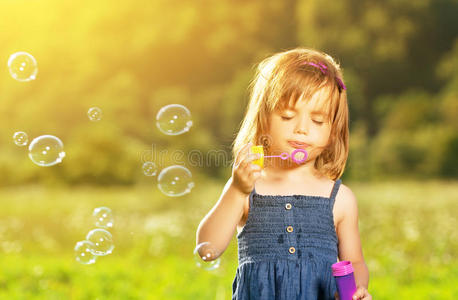 小女孩在大自然里吹肥皂泡