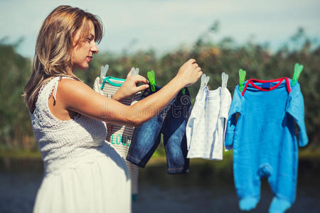 妈妈挂衣服爱心妈妈把婴儿衣服挂在绳子上照片
