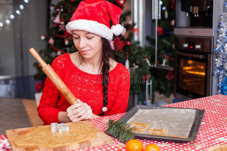 戴着圣诞帽的年轻女子在烤姜饼