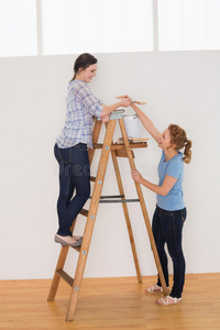 两个女朋友在新房子里用梯子