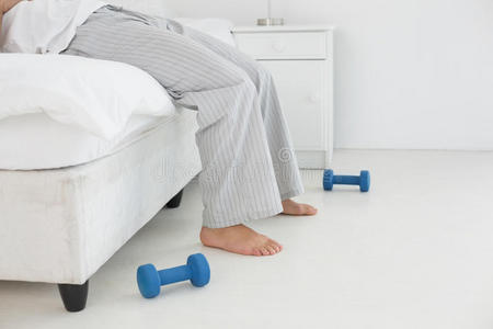 一个穿着睡衣的男人躺在床上的低矮部分