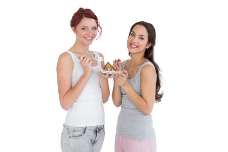 两个快乐的年轻女性朋友一起吃糕点