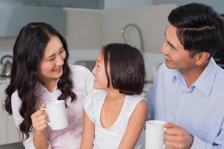 快乐的小女孩和父母一起吃早餐