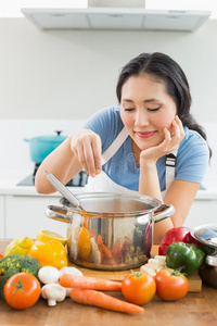 微笑的年轻女子在厨房准备食物