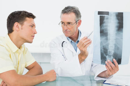 医生在办公室给病人讲解脊柱x光片