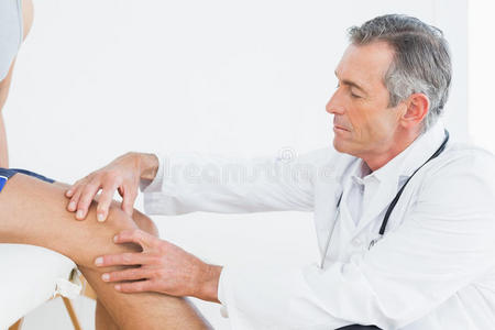 成熟医生检查病人膝关节的侧视图