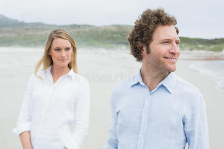 海滩上一对笑容可掬的年轻夫妇