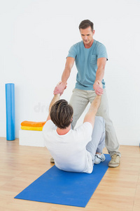 男性治疗师协助男性做伸展运动图片