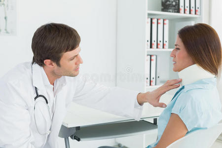 医生在医务室检查病人的颈部