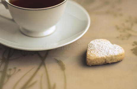 一杯心形的茶和饼干。