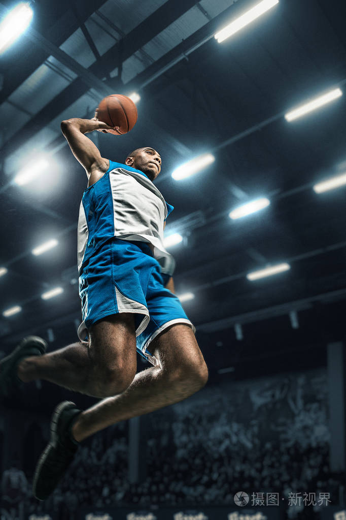 篮球运动员在大的专业竞技场比赛期间.篮球运动员打扣篮