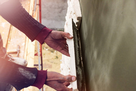建筑工人用铲子轻轻地敲击瓷砖。 建筑工程