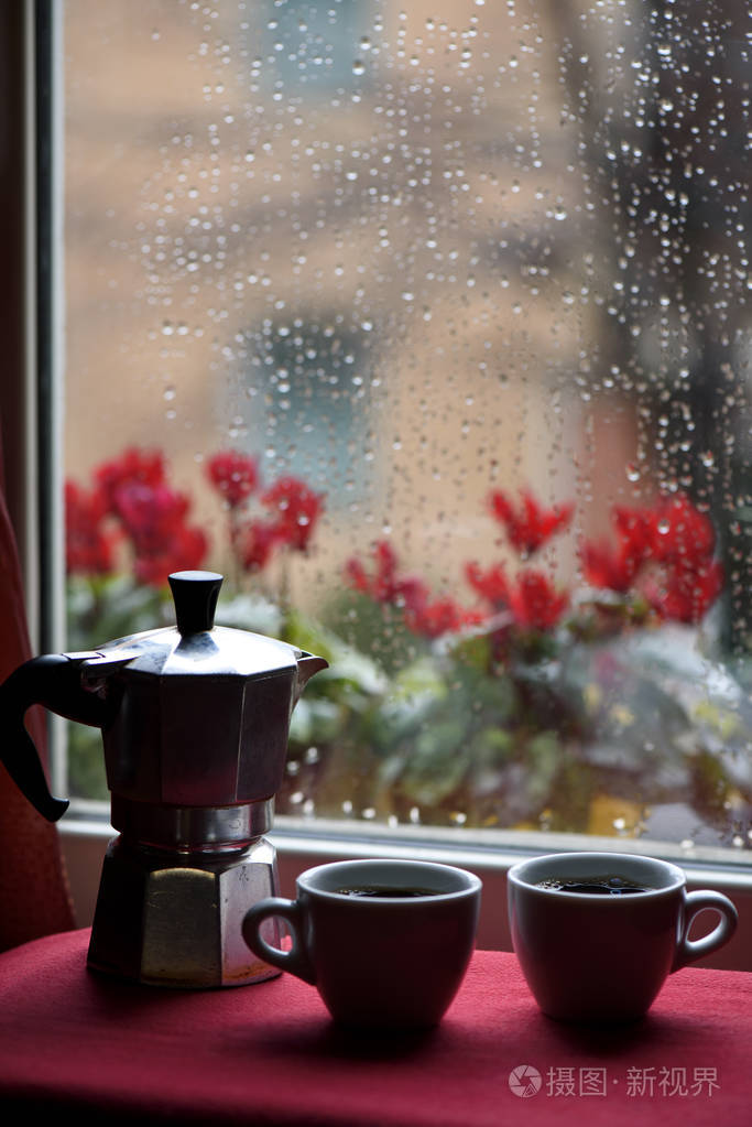 raind 窗前杯热咖啡和浓咖啡机