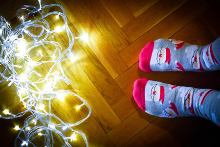 s legs in seasonal winter socks with Christmas decoration. Funny