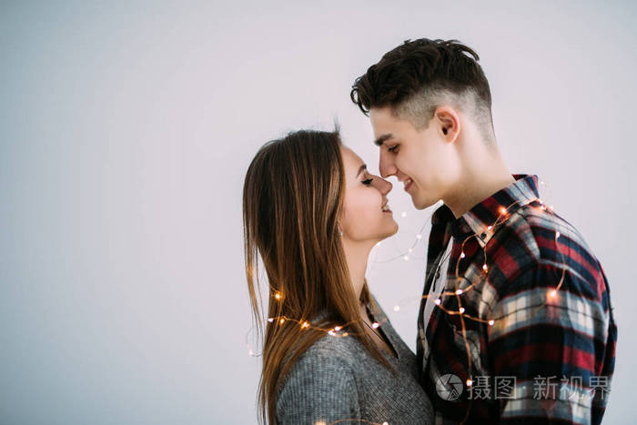 年轻情侣在爱拥抱在白色背景上的颈部照明