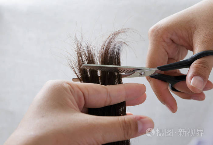 特写理发师修剪棕色头发用剪刀照片-正版商用图片11iw9e-摄图新视界