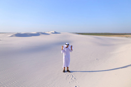 快乐的阿拉伯男人走在中间的白色沙漠和享有生活 o